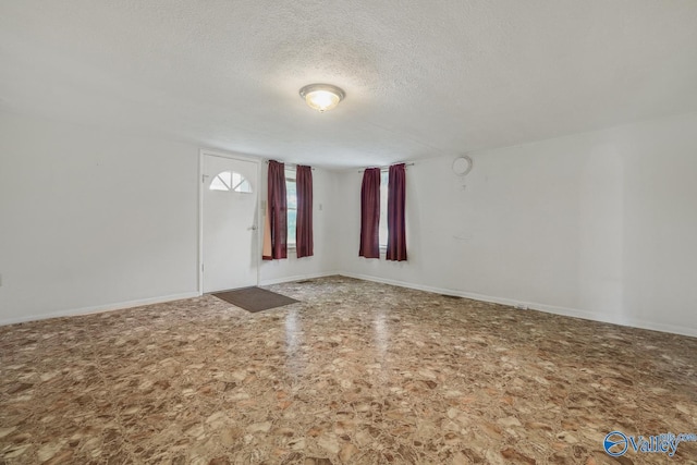 unfurnished room featuring a textured ceiling