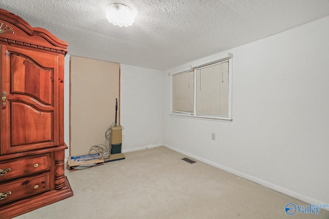 unfurnished bedroom featuring light colored carpet and a textured ceiling