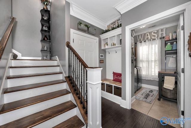 stairway with wood-type flooring and crown molding