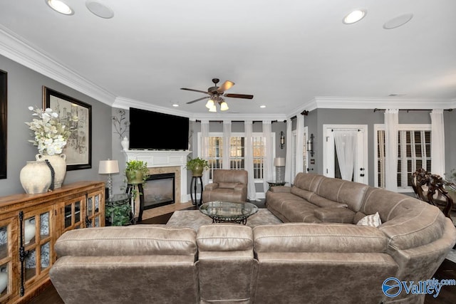 living room featuring wood-type flooring, ceiling fan, and crown molding