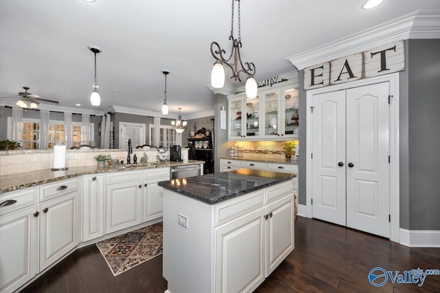 kitchen with a center island, hanging light fixtures, tasteful backsplash, dark hardwood / wood-style floors, and white cabinets