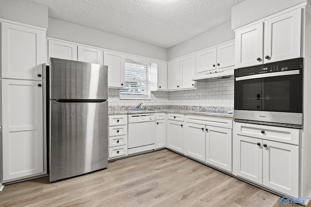 1201 Bailey Cove Cir SE # D, Huntsville, AL 35802 - kitchen featuring stainless steel appliances, a textured ceiling, a sink, white cabinets, and tasteful backsplash
