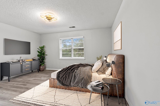 1201 Bailey Cove Cir SE # D, Huntsville, AL 35802 - bedroom with a textured ceiling, light wood-type flooring, and baseboards