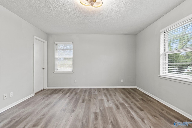 1201 Bailey Cove Cir SE # D, Huntsville, AL 35802 - unfurnished room featuring a textured ceiling, wood finished floors, and baseboards