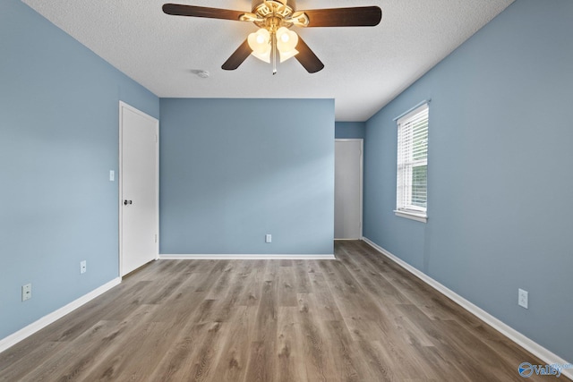 1201 Bailey Cove Cir SE # D, Huntsville, AL 35802 - unfurnished room with a textured ceiling, wood finished floors, ceiling fan, baseboards, and a smoke detector