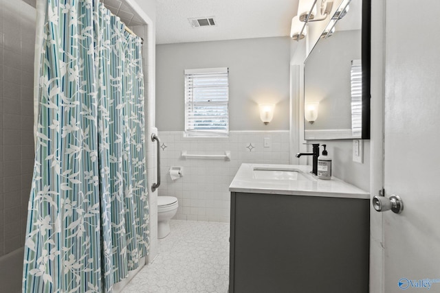 1201 Bailey Cove Cir SE # D, Huntsville, AL 35802 - bathroom with curtained shower, vanity, toilet, tile walls, and a wainscoted wall