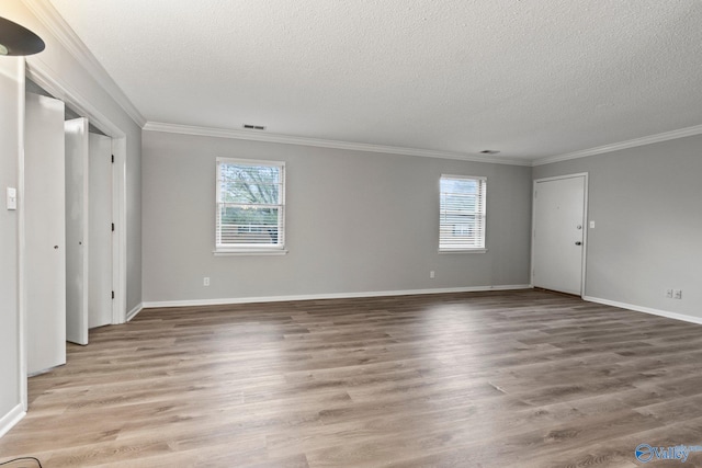 1201 Bailey Cove Cir SE # D, Huntsville, AL 35802 - unfurnished living room featuring a textured ceiling, ornamental molding, light wood-style flooring, and baseboards