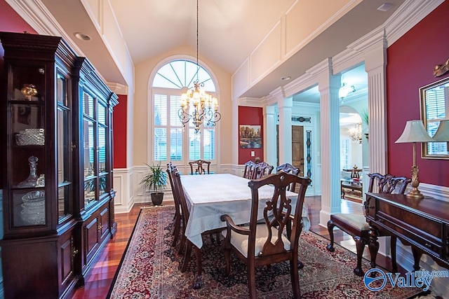 dining space featuring an inviting chandelier, a wealth of natural light, high vaulted ceiling, and dark wood-type flooring