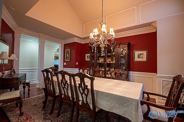 dining area with an inviting chandelier, high vaulted ceiling, hardwood / wood-style flooring, and ornamental molding