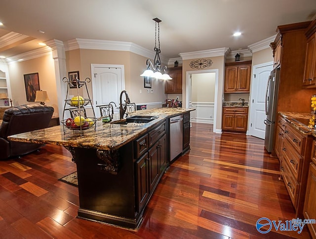 kitchen with dark stone countertops, appliances with stainless steel finishes, dark hardwood / wood-style flooring, and an island with sink