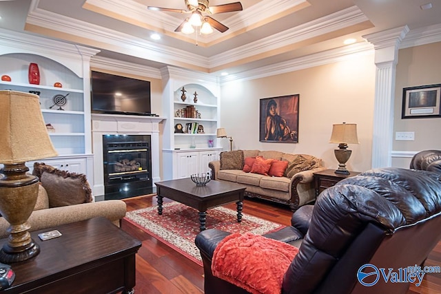 living room with ornamental molding, dark hardwood / wood-style flooring, and a tray ceiling