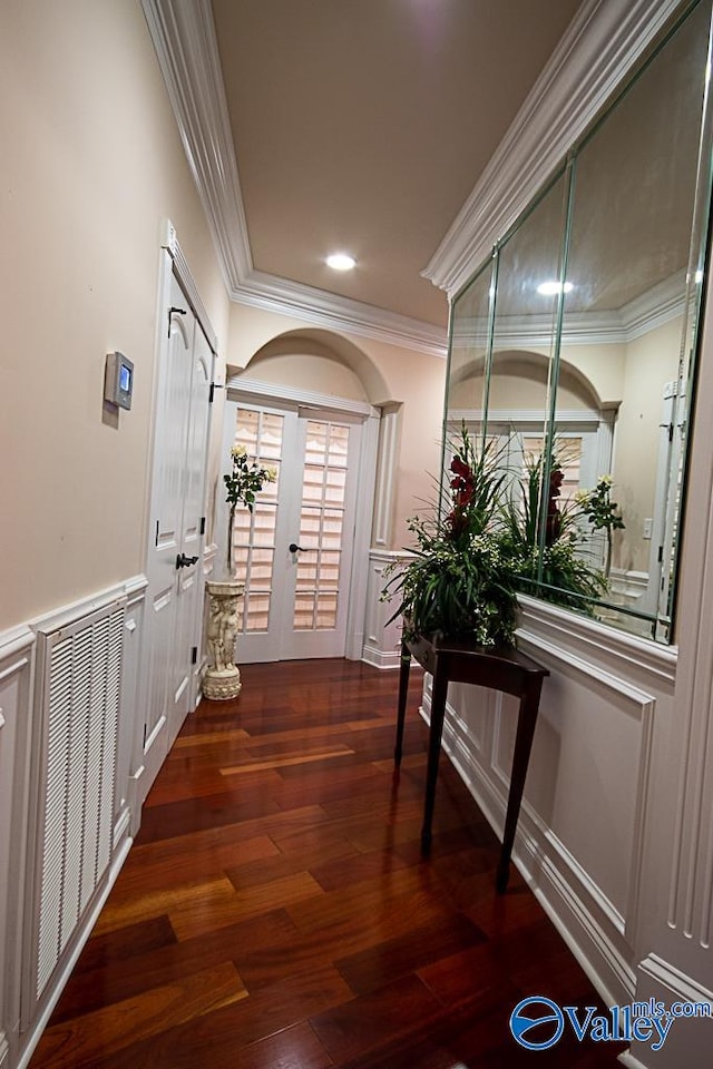 corridor with french doors, wood-type flooring, and ornamental molding