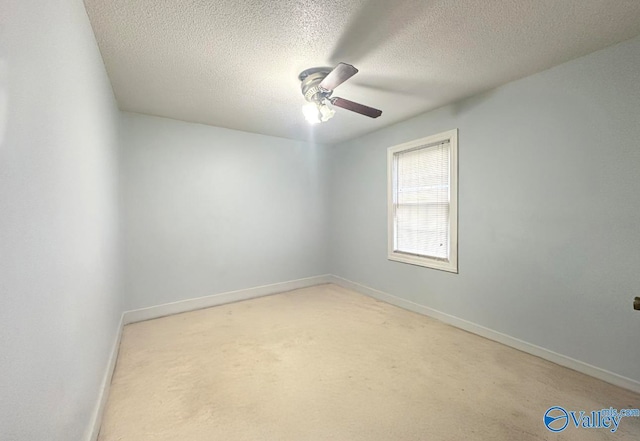 carpeted spare room with ceiling fan and a textured ceiling