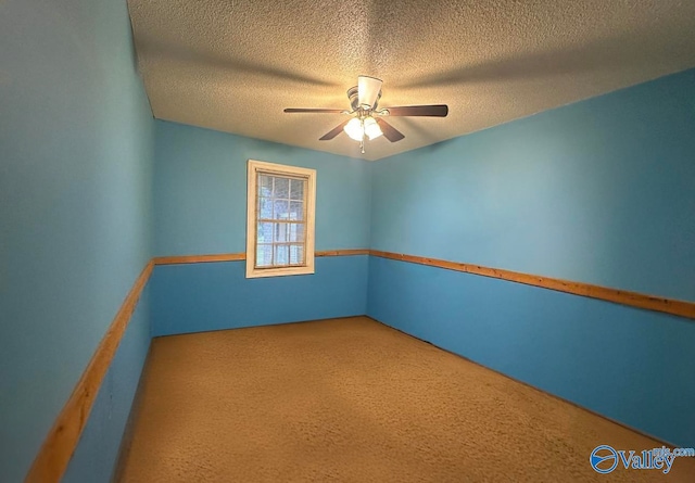 empty room featuring a textured ceiling, carpet floors, and ceiling fan