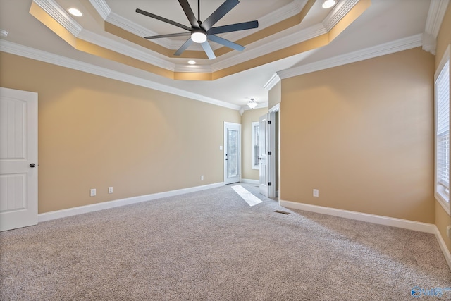 carpeted empty room featuring baseboards, a tray ceiling, ceiling fan, and crown molding