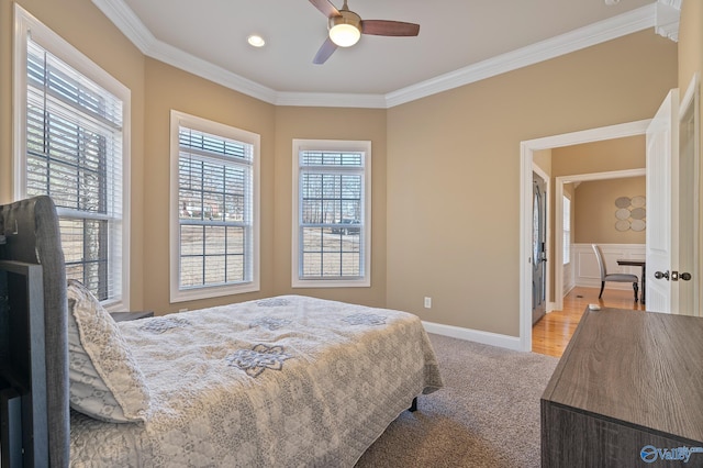 carpeted bedroom featuring ornamental molding, a ceiling fan, and baseboards