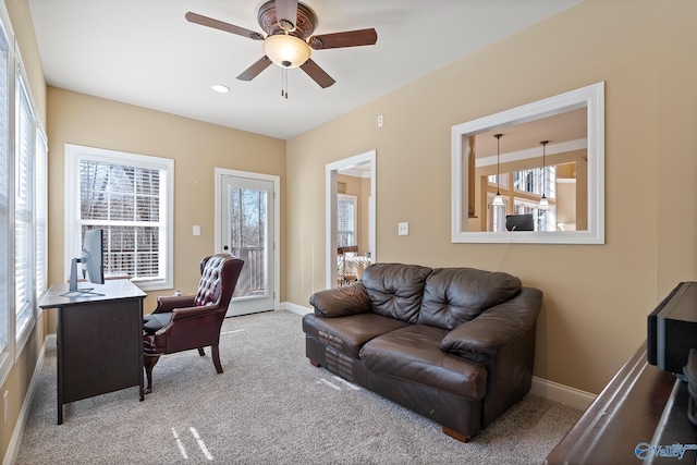 carpeted office space with ceiling fan and baseboards