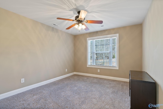 carpeted empty room featuring baseboards, visible vents, and ceiling fan