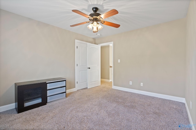 unfurnished bedroom featuring a ceiling fan, carpet, and baseboards