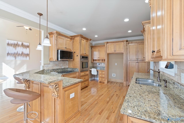 kitchen featuring appliances with stainless steel finishes, a peninsula, light stone countertops, a sink, and backsplash