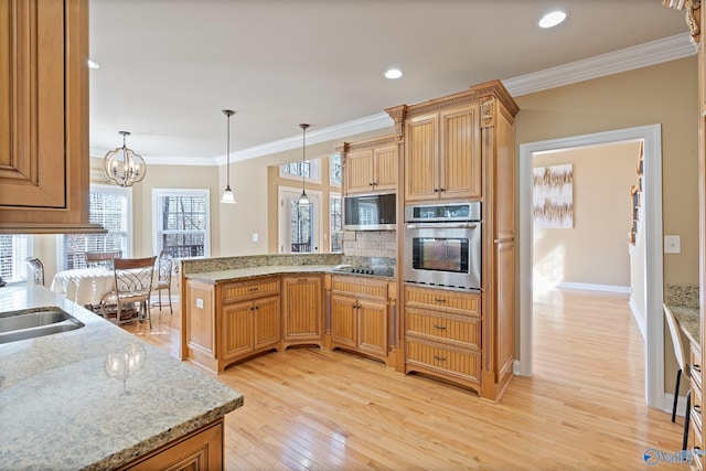 kitchen featuring ornamental molding, a peninsula, appliances with stainless steel finishes, and light wood-type flooring