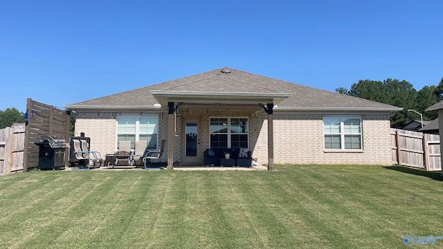 rear view of property with a yard and a patio area