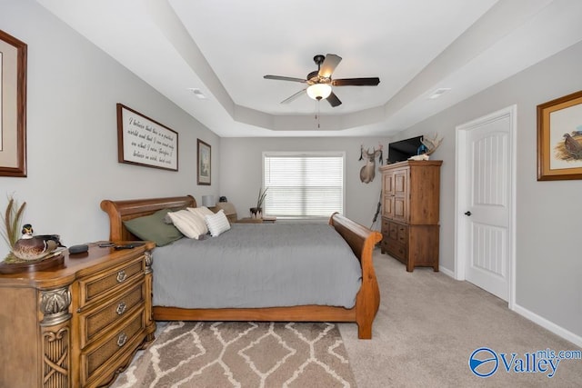 bedroom featuring a tray ceiling, ceiling fan, and light colored carpet