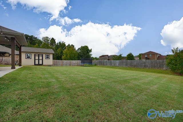 view of yard featuring an outdoor structure and a trampoline