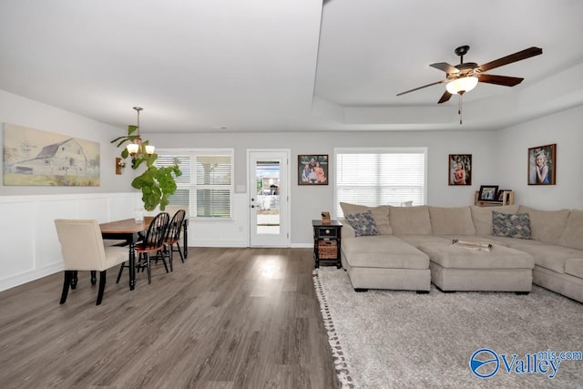 living room featuring a wealth of natural light, hardwood / wood-style floors, and ceiling fan with notable chandelier