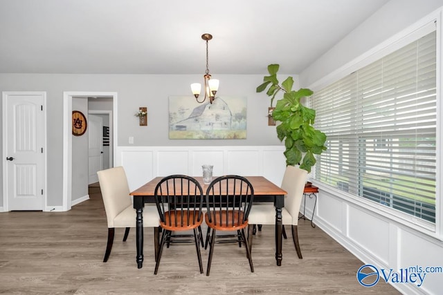 dining room with wood-type flooring and a chandelier