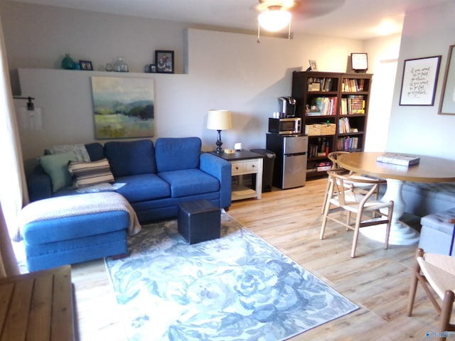 living room with wood-type flooring and ceiling fan