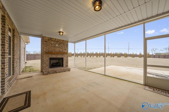 unfurnished sunroom featuring an outdoor brick fireplace