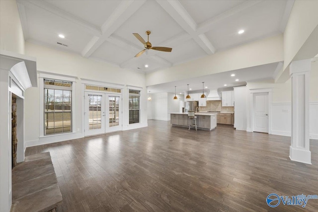 unfurnished living room featuring dark hardwood / wood-style flooring, coffered ceiling, french doors, and beamed ceiling