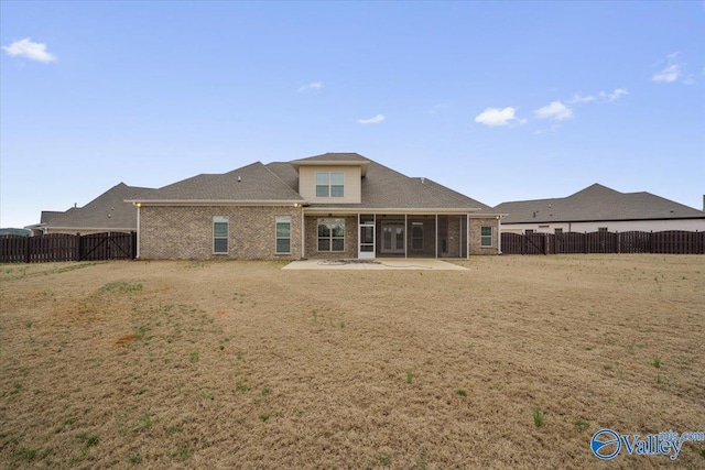 back of house with a patio area and a lawn