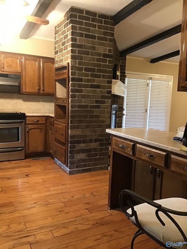 kitchen with beamed ceiling, stainless steel stove, and light hardwood / wood-style flooring