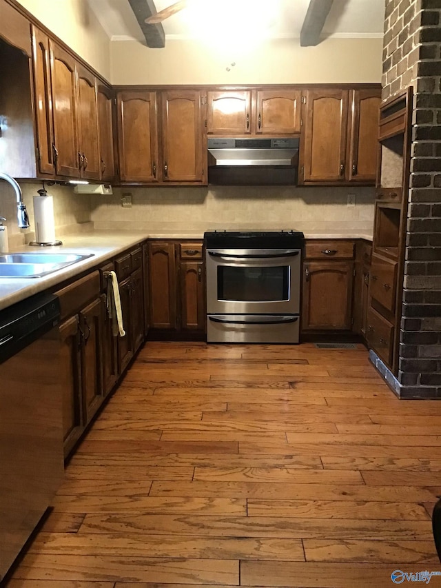 kitchen featuring tasteful backsplash, stainless steel appliances, light hardwood / wood-style floors, and sink