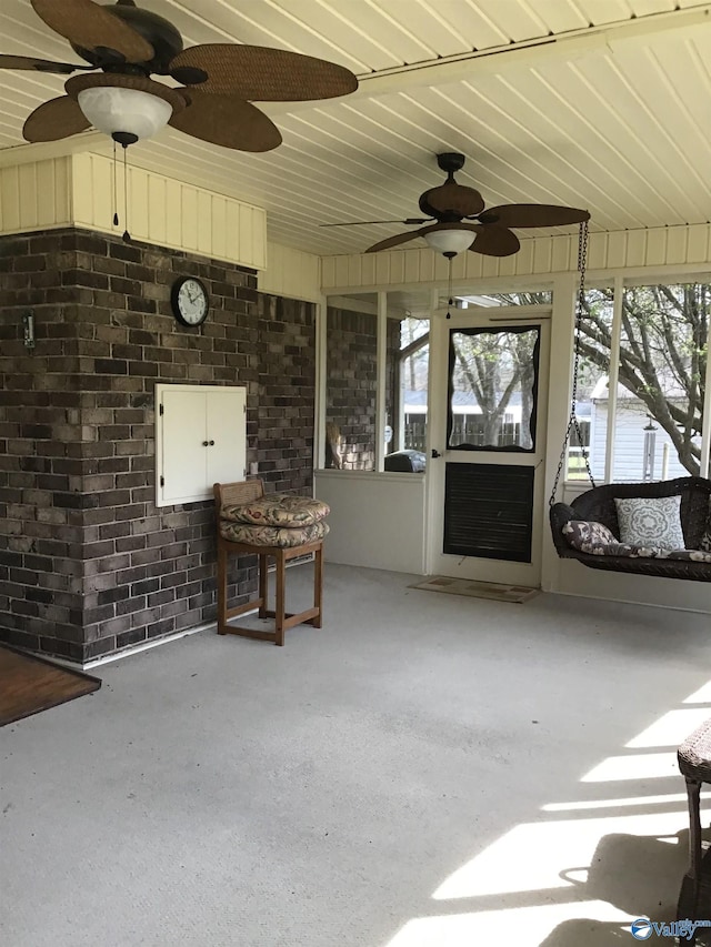 unfurnished sunroom featuring ceiling fan