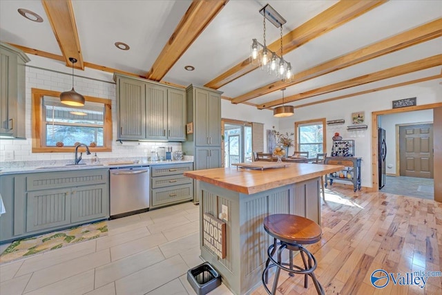 kitchen with a breakfast bar, beam ceiling, tasteful backsplash, butcher block counters, and stainless steel dishwasher