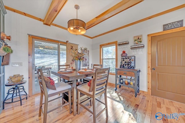 dining area with light wood-type flooring and beamed ceiling