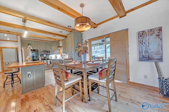 dining area with light wood-style flooring, baseboards, and beam ceiling