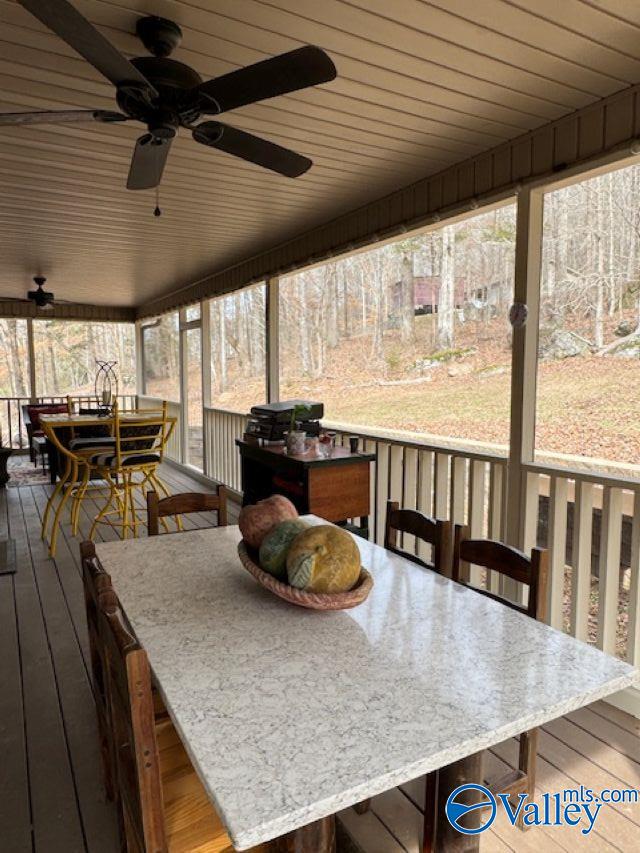 sunroom featuring wood ceiling and a ceiling fan