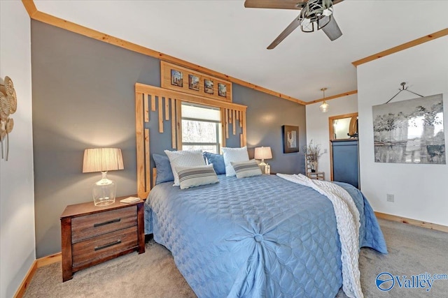 carpeted bedroom featuring ornamental molding, ceiling fan, and baseboards