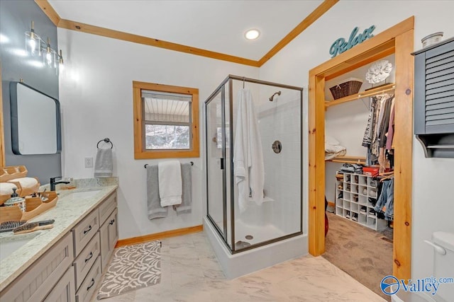 full bathroom with marble finish floor, a stall shower, a sink, and crown molding