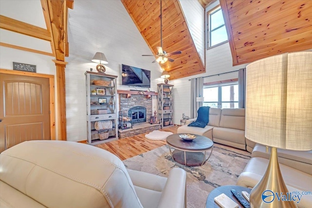 living area with a ceiling fan, wooden ceiling, wood finished floors, a fireplace, and high vaulted ceiling