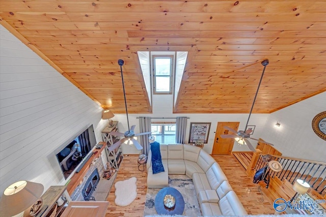 living area with ceiling fan, high vaulted ceiling, wooden ceiling, a skylight, and wood finished floors