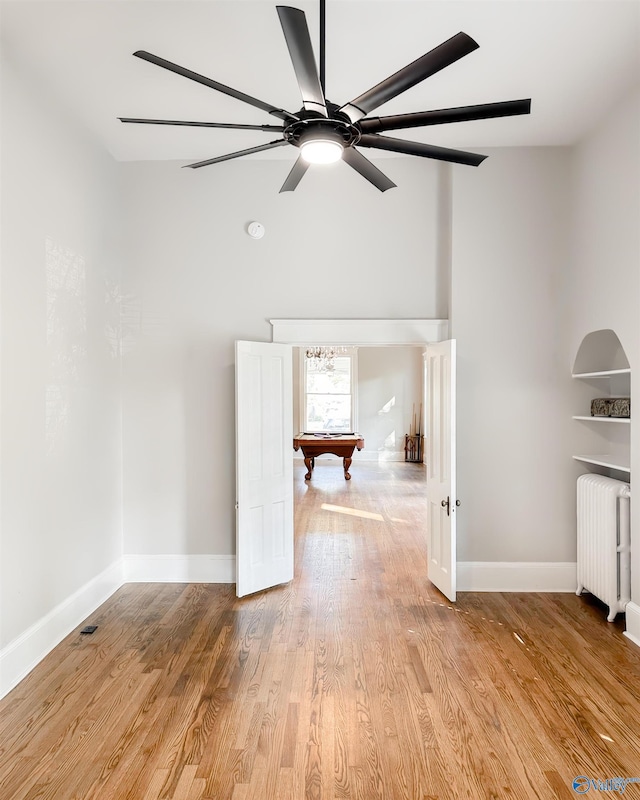 605 Ferry St, Decatur, AL 35601 - unfurnished room with radiator, billiards, baseboards, a towering ceiling, and light wood-type flooring