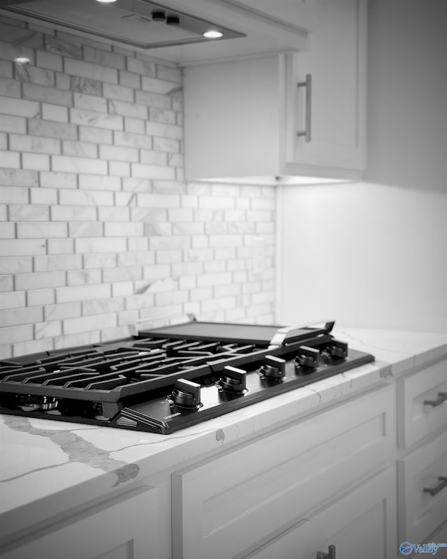 605 Ferry St, Decatur, AL 35601 - kitchen view of black gas cooktop, tasteful backsplash, white cabinetry, and light stone counters
