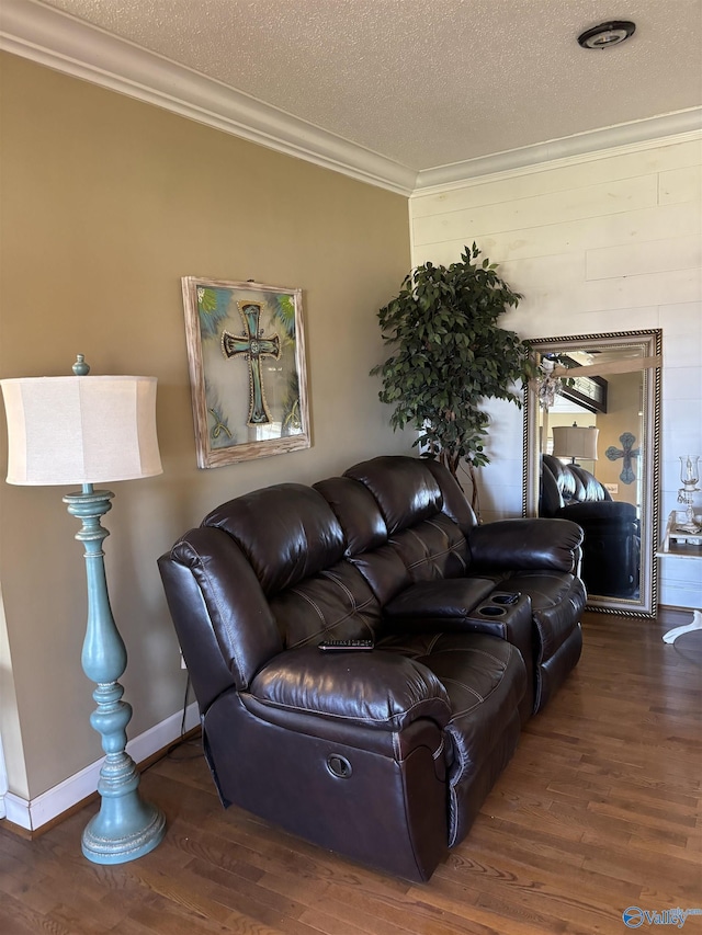 living area featuring baseboards, wood finished floors, a textured ceiling, and crown molding