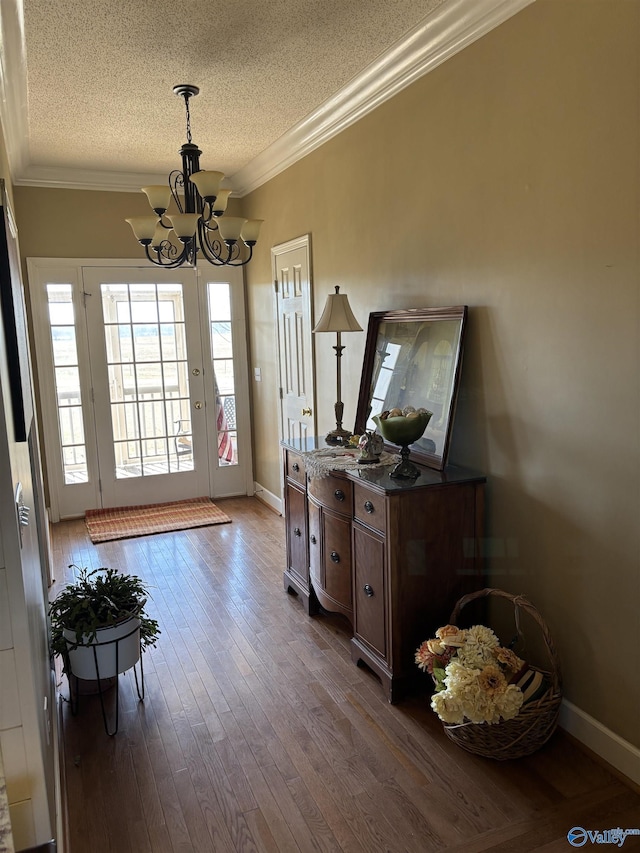 interior space featuring dark wood-style floors, crown molding, baseboards, a chandelier, and a textured ceiling