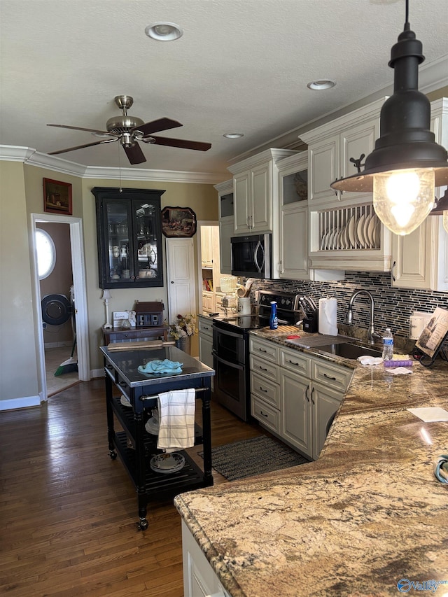 kitchen featuring a sink, ceiling fan, appliances with stainless steel finishes, backsplash, and ornamental molding